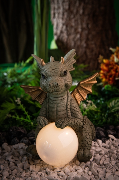 Babydrache Emu, Drache aus Kunstharz hält eine Solar-Lichtkugel vor sich zwischen 2 Pfoten